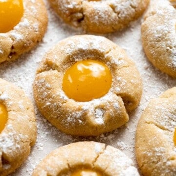 Sweet and sour Lemon Curd Cookies are made of buttery shortbread thumbprint cookies dusted with powdered sugar, and filled with sweet and tangy lemon curd. | aheadofthyme.com