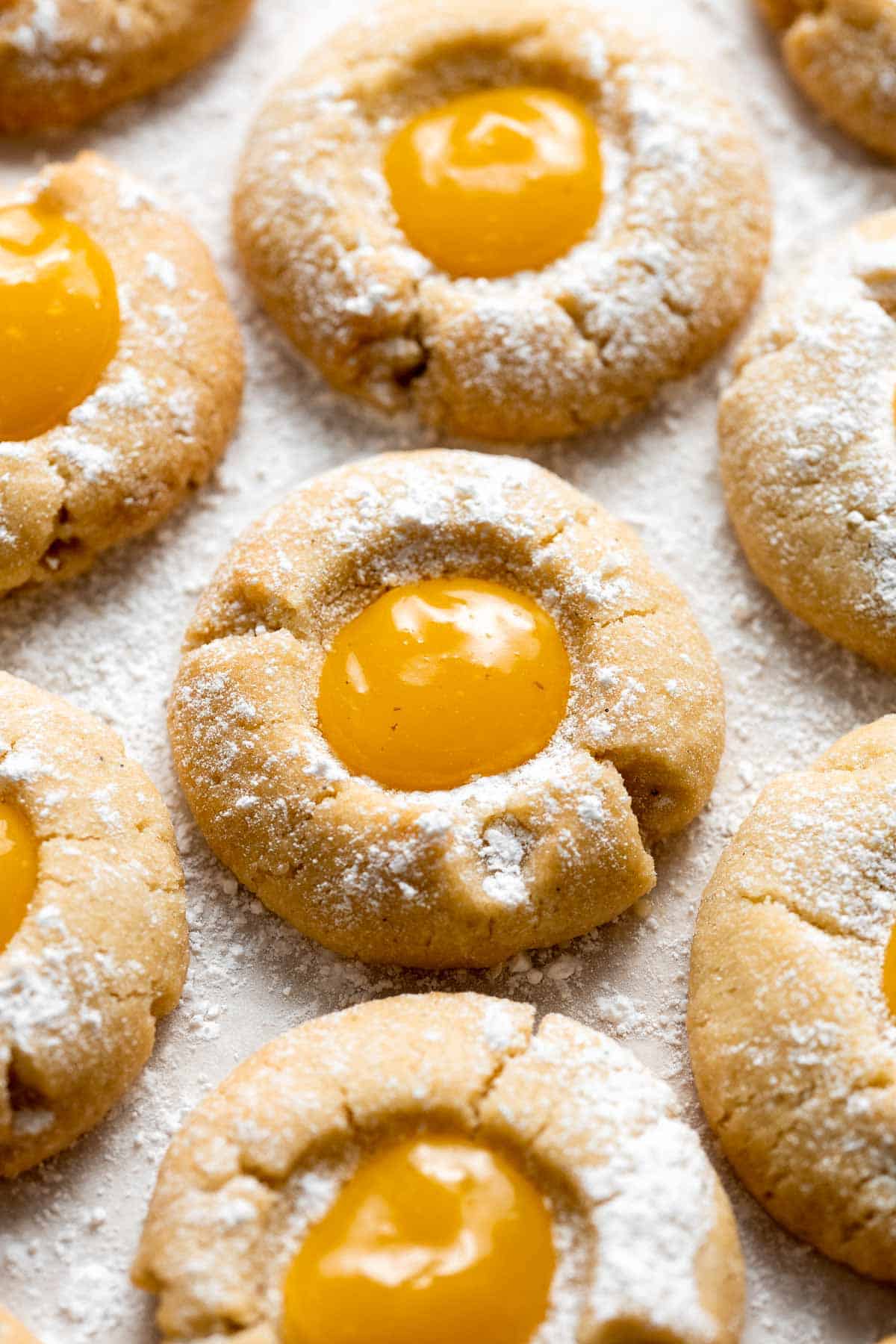 Sweet and sour Lemon Curd Cookies are made of buttery shortbread thumbprint cookies dusted with powdered sugar, and filled with sweet and tangy lemon curd. | aheadofthyme.com