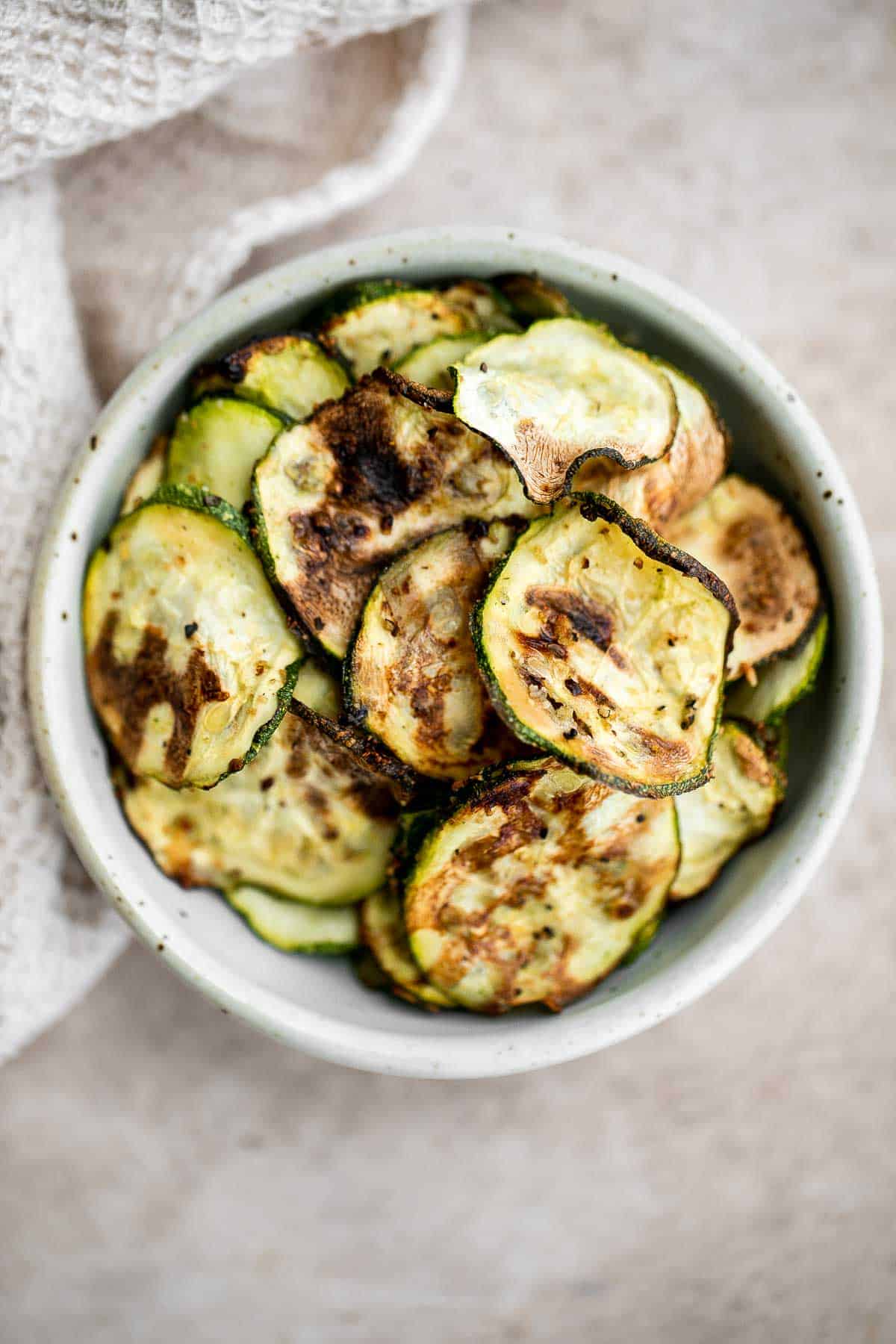 Air fryer zucchini chips make an excellent snack or side dish — they are savory, salty, and flavorful! A quick and easy recipe made with 5 ingredients. | aheadofthyme.com