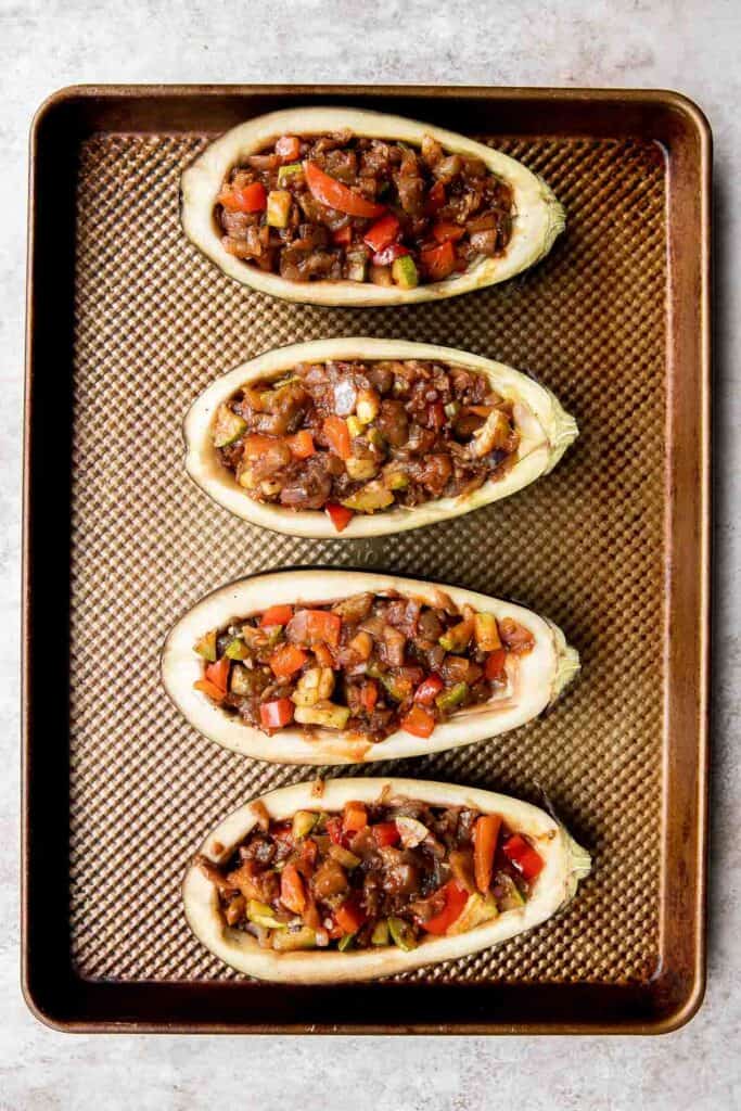 This Mediterranean Stuffed Eggplant is delicious, filling, and healthy. This vegetarian dinner is loaded with veggies and topped with bubbly cheese. | aheadofthyme.com