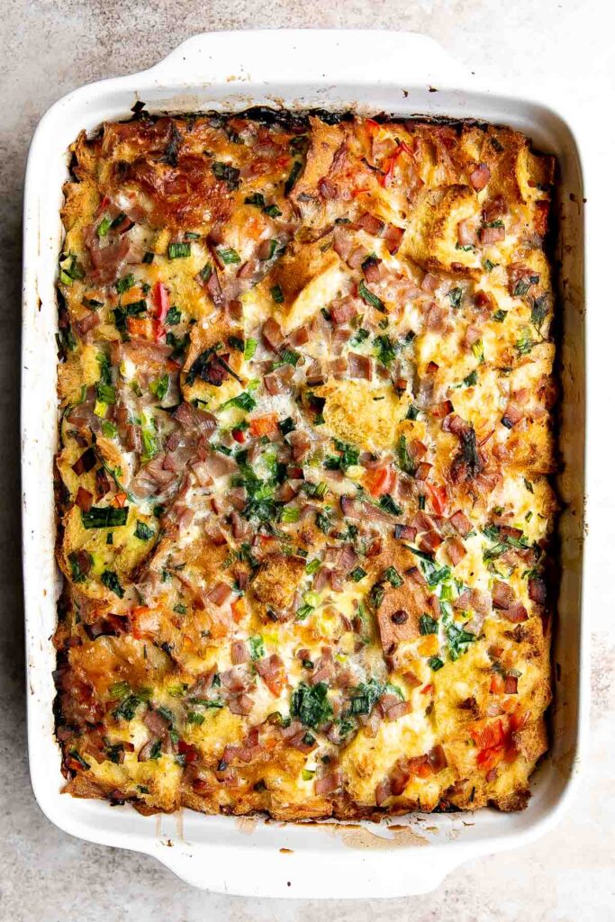 Breakfast Strata is a hearty baked casserole dish loaded with bread, eggs, ham, cheese, and veggies that will keep you full until lunchtime. | aheadofthyme.com