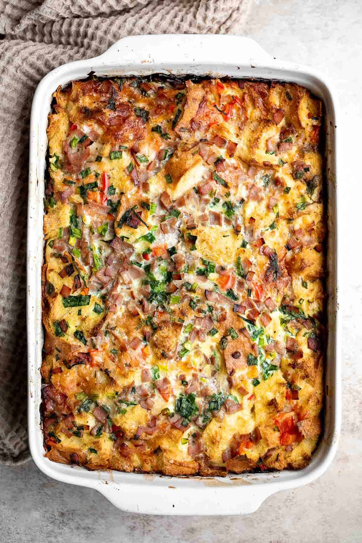 Breakfast Strata is a hearty baked casserole dish loaded with bread, eggs, ham, cheese, and veggies that will keep you full until lunchtime. | aheadofthyme.com