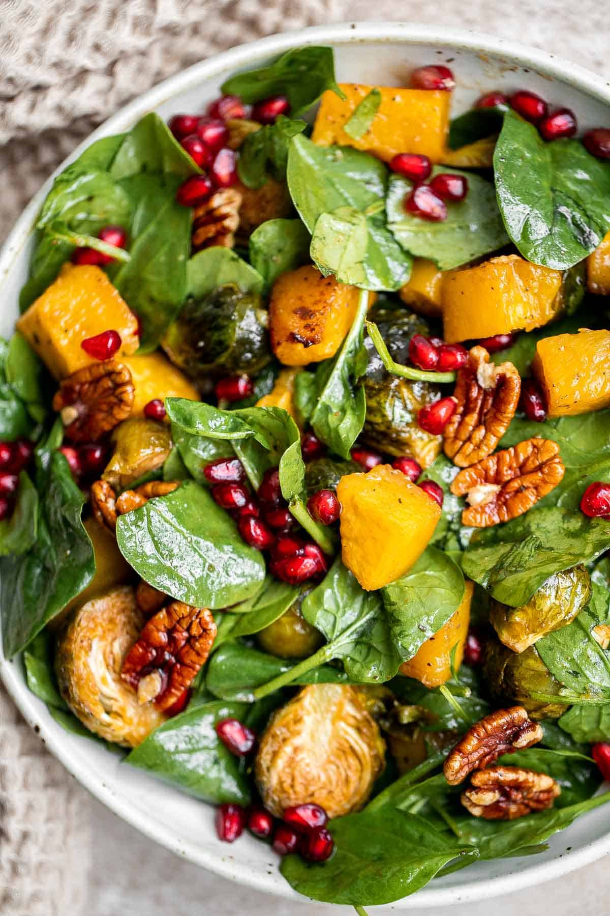 This simple and healthy Thanksgiving Salad is loaded with greens, seasonal veggies, pomegranate seeds, and pecans, all tossed in a homemade vinaigrette. | aheadofthyme.com
