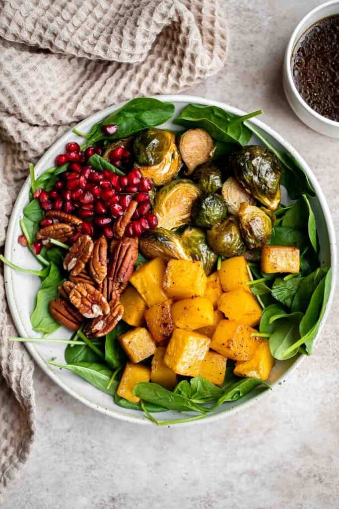 This simple and healthy Thanksgiving Salad is loaded with greens, seasonal veggies, pomegranate seeds, and pecans, all tossed in a homemade vinaigrette. | aheadofthyme.com