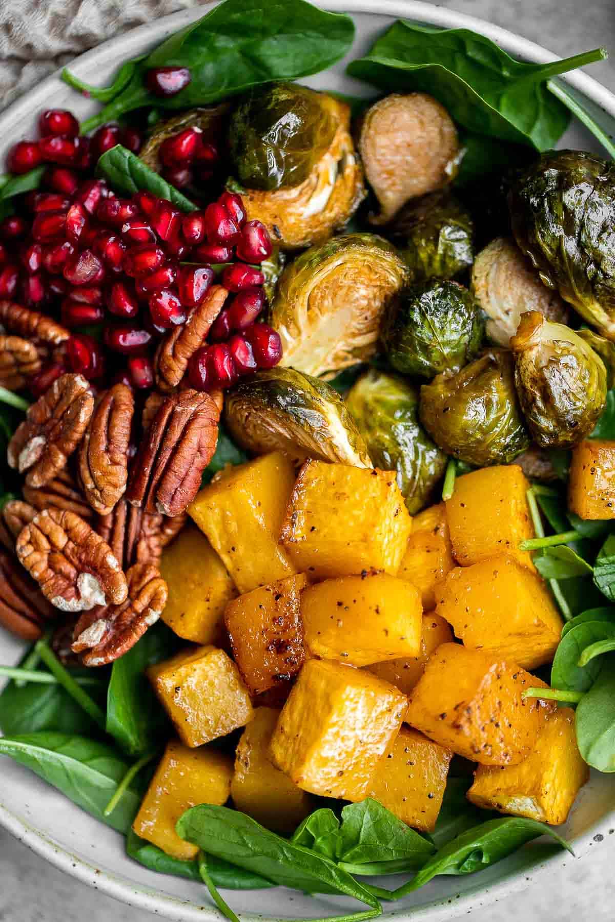 This simple and healthy Thanksgiving Salad is loaded with greens, seasonal veggies, pomegranate seeds, and pecans, all tossed in a homemade vinaigrette. | aheadofthyme.com