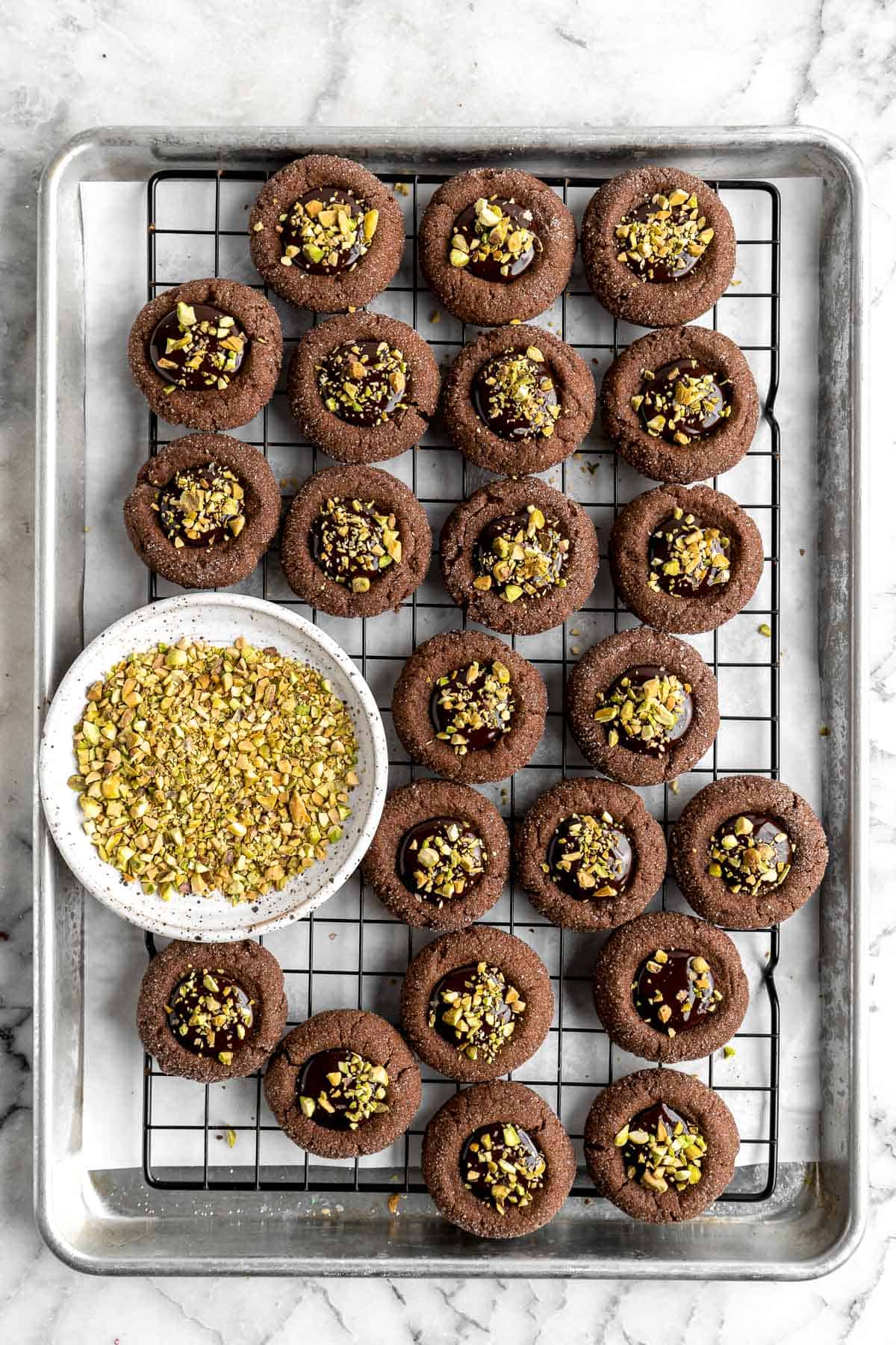 Chocolate Thumbprint Cookies are rich and chewy chocolate cookies with a smooth and velvety chocolate ganache filling topped with crunchy pistachios. | aheadofthyme.com