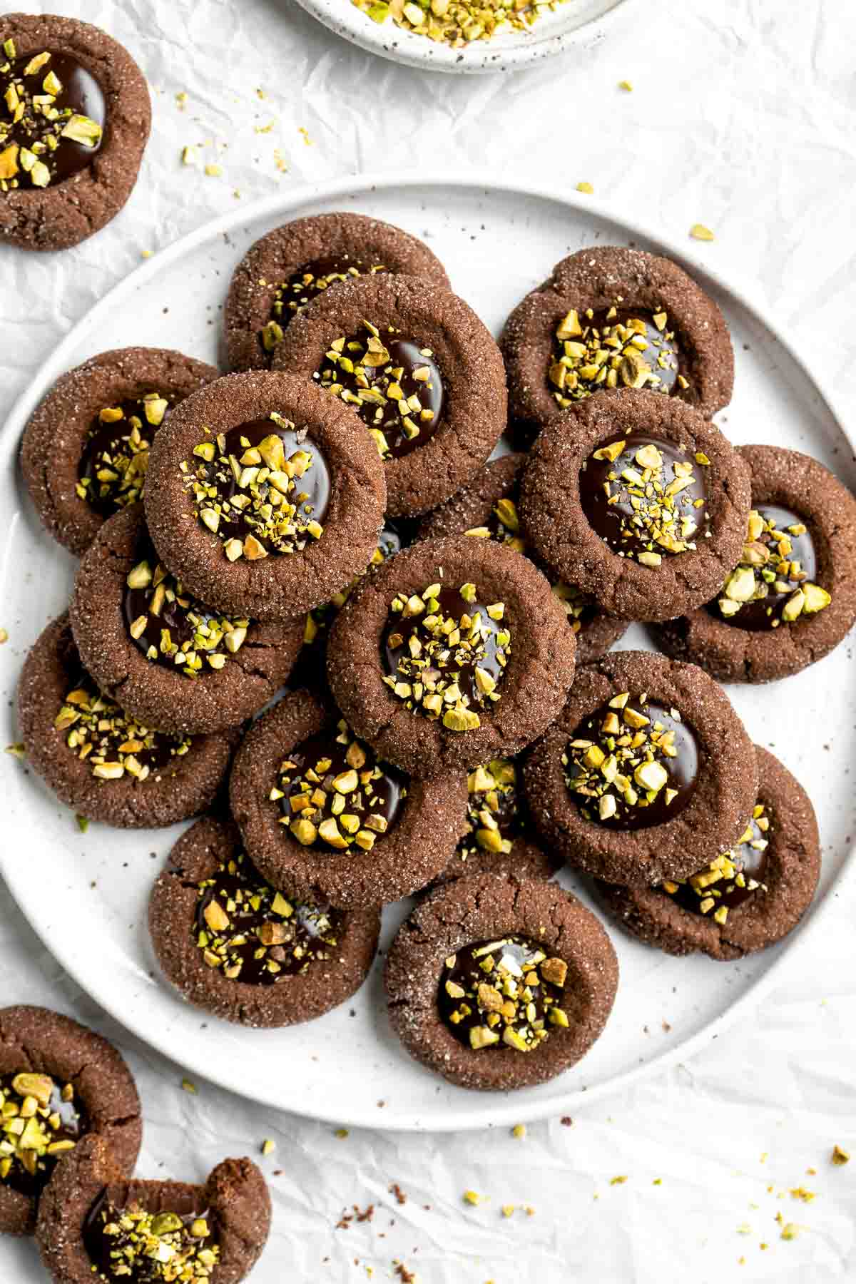 Chocolate Thumbprint Cookies are rich and chewy chocolate cookies with a smooth and velvety chocolate ganache filling topped with crunchy pistachios. | aheadofthyme.com