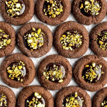 Chocolate Thumbprint Cookies are rich and chewy chocolate cookies with a smooth and velvety chocolate ganache filling topped with crunchy pistachios. | aheadofthyme.com