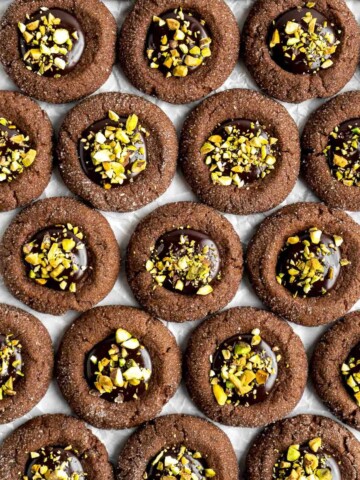 Chocolate Thumbprint Cookies are rich and chewy chocolate cookies with a smooth and velvety chocolate ganache filling topped with crunchy pistachios. | aheadofthyme.com