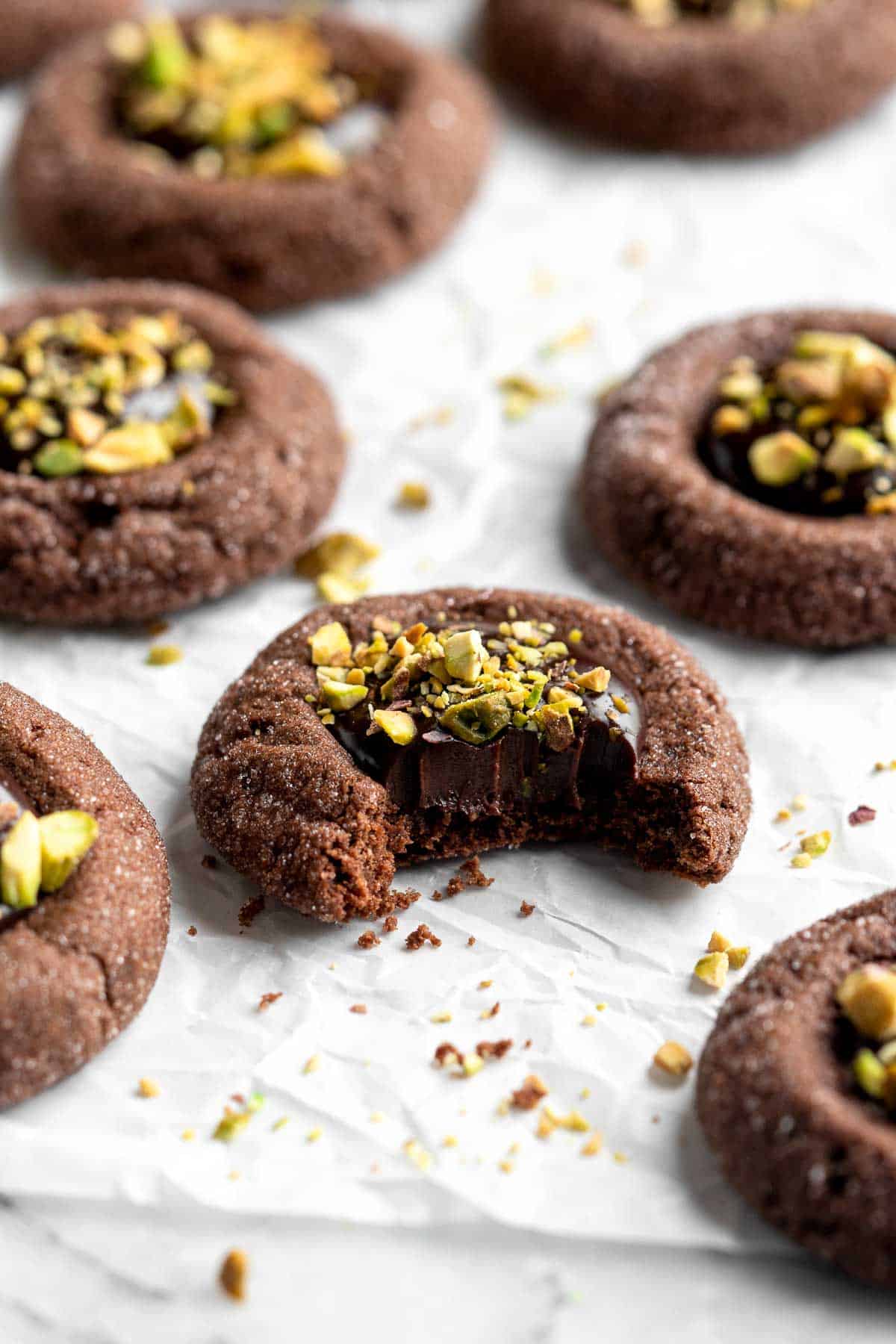 Chocolate Thumbprint Cookies are rich and chewy chocolate cookies with a smooth and velvety chocolate ganache filling topped with crunchy pistachios. | aheadofthyme.com