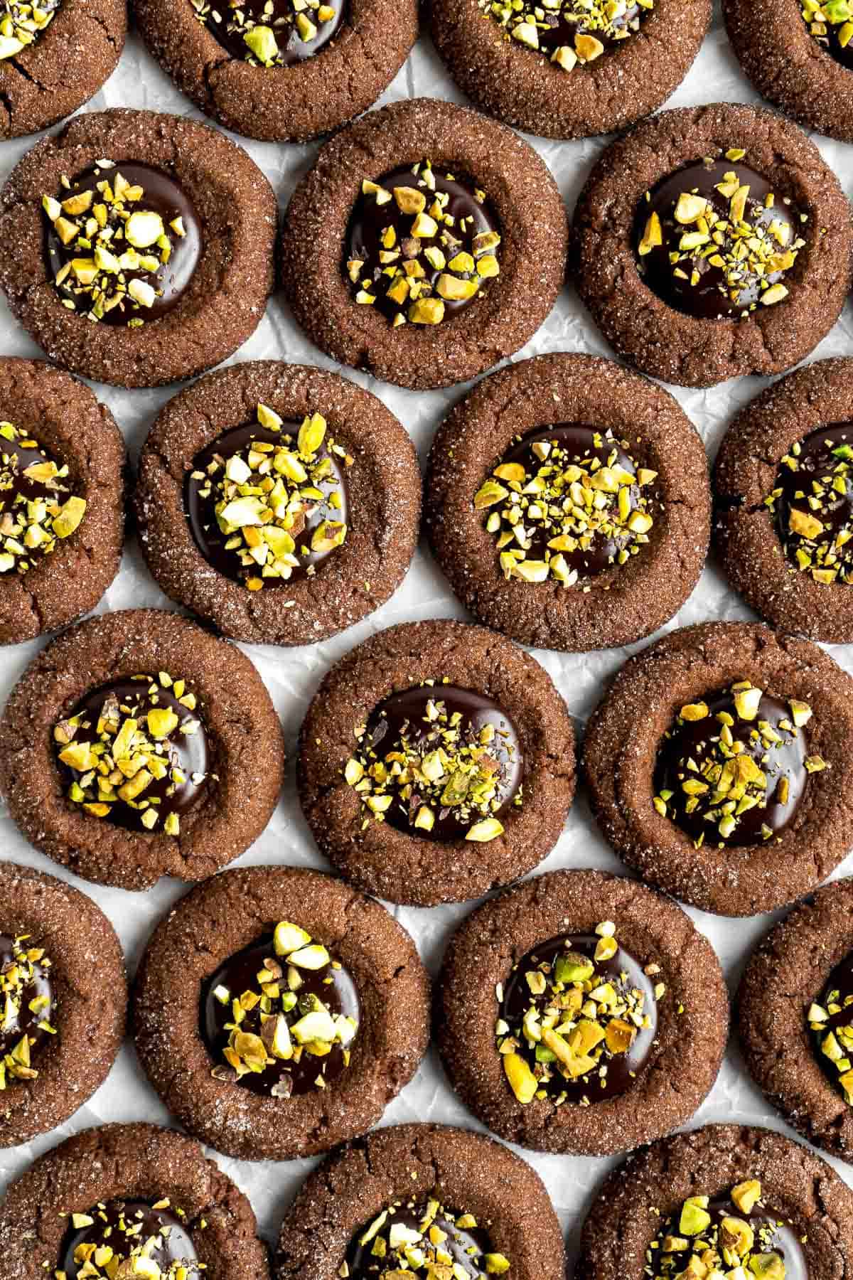 Chocolate Thumbprint Cookies are rich and chewy chocolate cookies with a smooth and velvety chocolate ganache filling topped with crunchy pistachios. | aheadofthyme.com