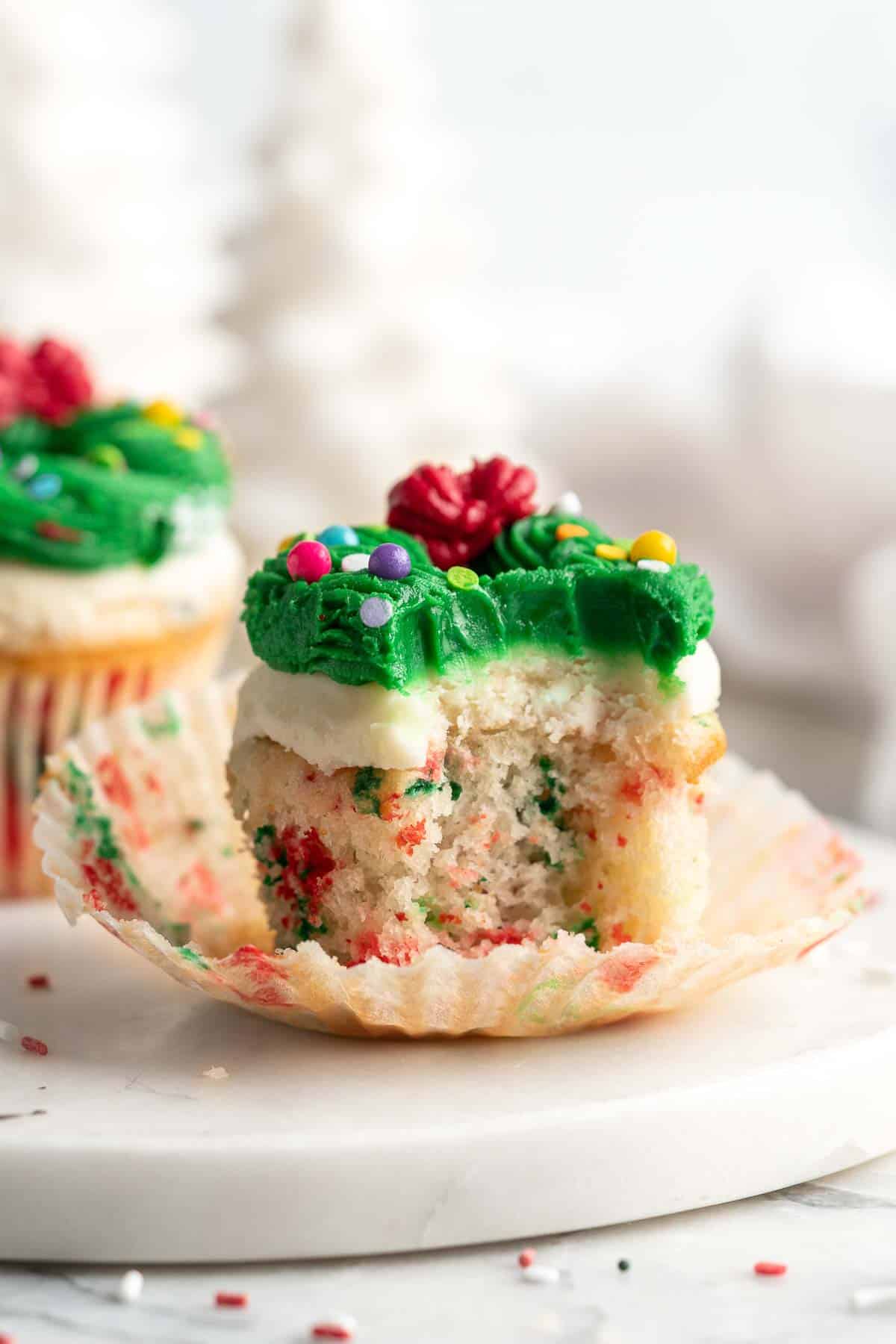 These festive Christmas Cupcakes are made of moist and fluffy vanilla funfetti cake topped with red and green buttercream frosting. So fun to make! | aheadofthyme.com