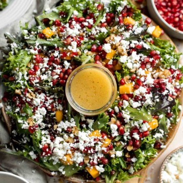 This fresh and festive Christmas Salad is made with delicious winter fruits and has a gorgeous wreath-like appearance. It’s earthy, sweet, nutty, and tangy. | aheadofthyme.com