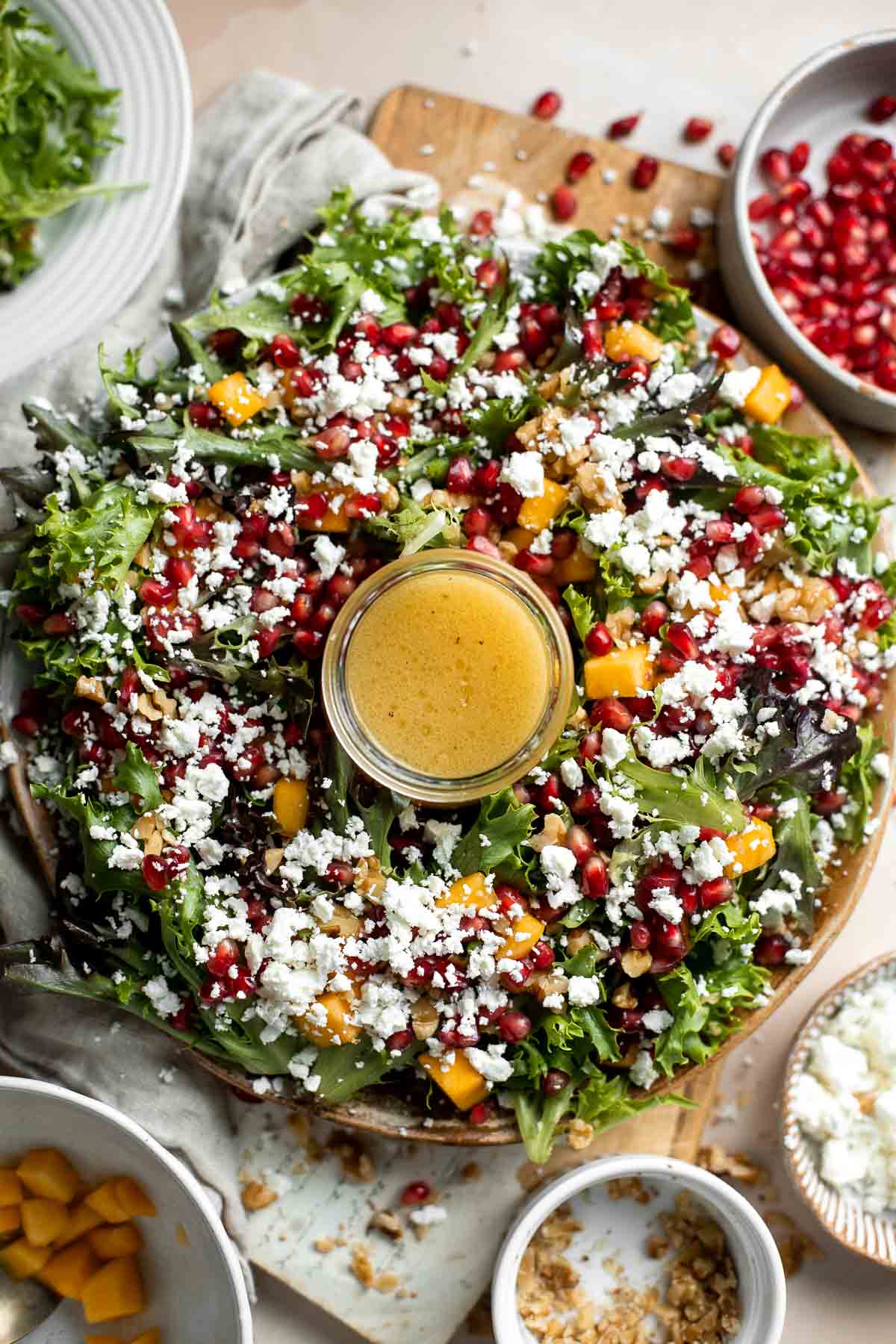 This fresh and festive Christmas Salad is made with delicious winter fruits and has a gorgeous wreath-like appearance. It’s earthy, sweet, nutty, and tangy. | aheadofthyme.com