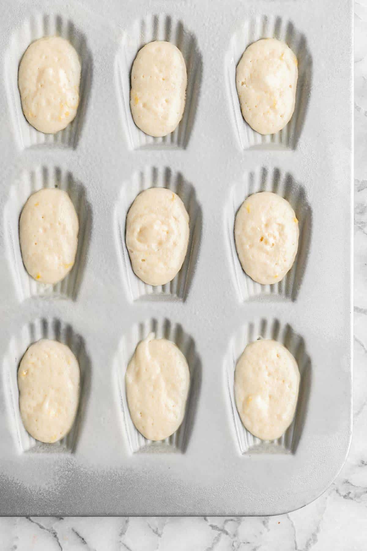 Classic Madeleines are soft spongy mini cakes with a signature shell shape and dusting of sugar on top. Making French butter cakes is easier than you think! | aheadofthyme.com