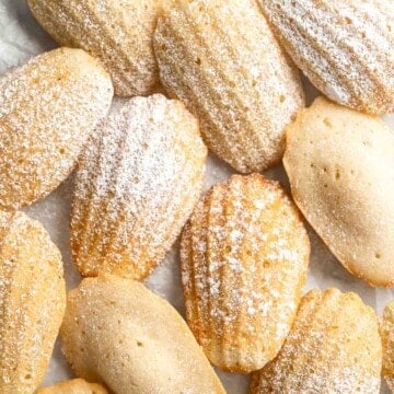 Classic Madeleines are soft spongy mini cakes with a signature shell shape and dusting of sugar on top. Making French butter cakes is easier than you think! | aheadofthyme.com