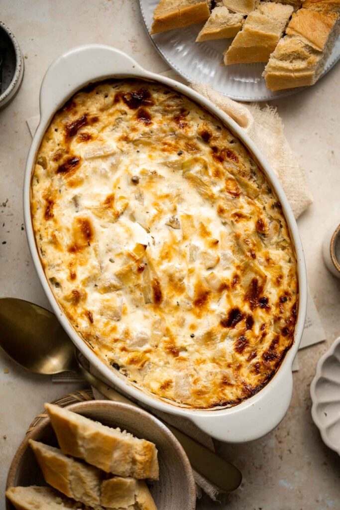 Homemade artichoke dip is a warm, creamy dip loaded with tender artichoke hearts. This easy to make appetizer is tangy, cheesy, and all-around delicious! | aheadofthyme.com