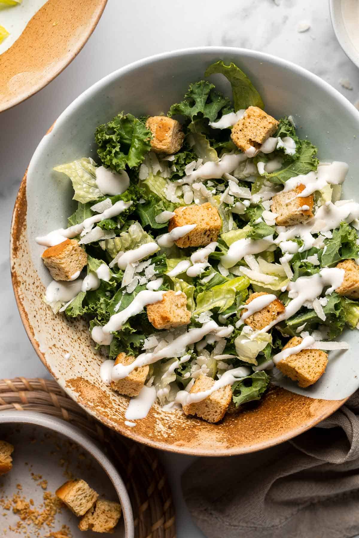 Kale Caesar Salad is a delicious, healthy twist on classic Caesar salad with all the traditional flavors but added crunch and rich earthiness of fresh kale. | aheadofthyme.com