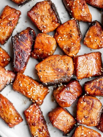 Salmon Bites are flavorful and delicious bite-sized pieces of salmon cooked until tender with crispy, golden edges and coated with an homemade sticky glaze. | aheadofthyme.com