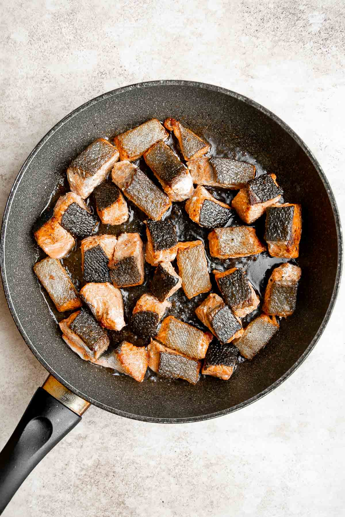 Salmon Bites are flavorful and delicious bite-sized pieces of salmon cooked until tender with crispy, golden edges and coated with an homemade sticky glaze. | aheadofthyme.com