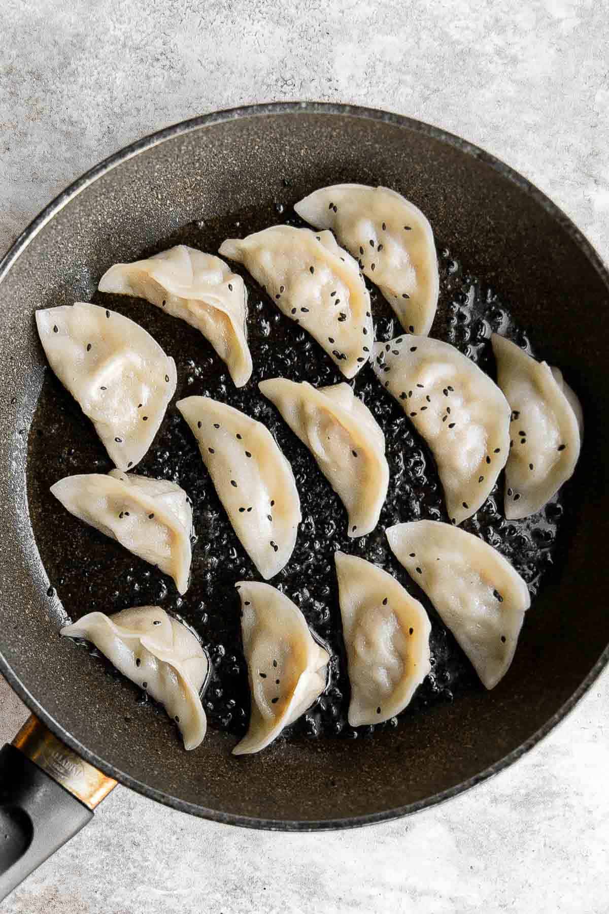 Kimchi Dumplings are savory, delicious, and flavorful. These Korean-inspired dumplings get seared and steamed to create classic crispy bottom potstickers. | aheadofthyme.com