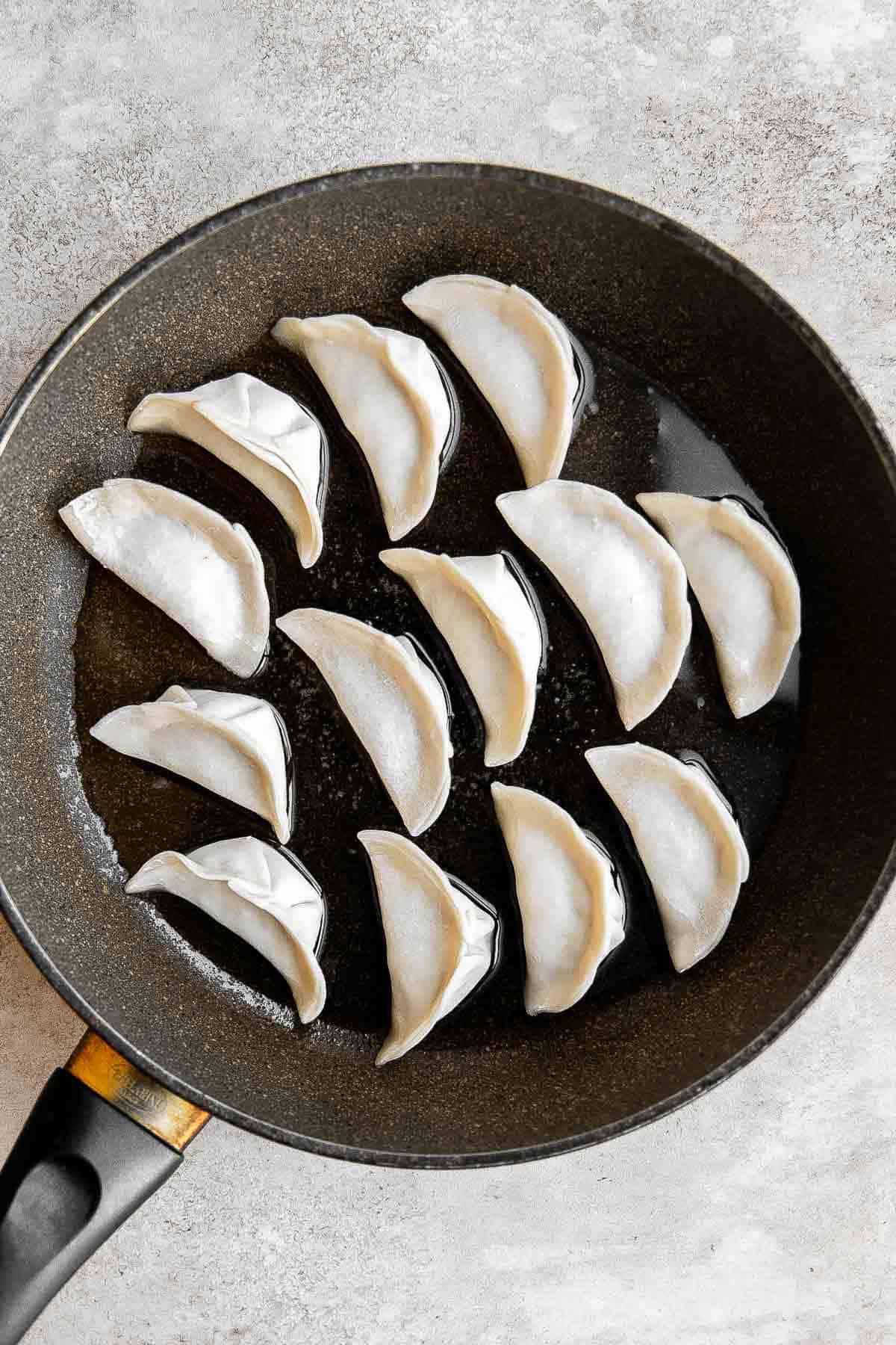 Kimchi Dumplings are savory, delicious, and flavorful. These Korean-inspired dumplings get seared and steamed to create classic crispy bottom potstickers. | aheadofthyme.com