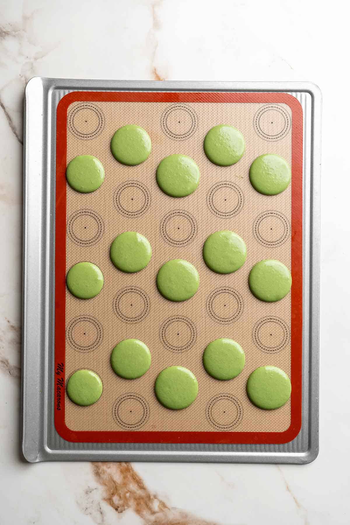 Pistachio Macarons are delicate, chewy, melt-in-your-mouth cookies filled with pistachio white chocolate ganache filling and chopped pistachios on top. | aheadofthyme.com