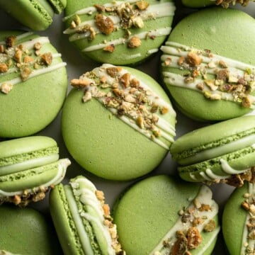 Pistachio Macarons are delicate, chewy, melt-in-your-mouth cookies filled with pistachio white chocolate ganache filling and chopped pistachios on top. | aheadofthyme.com