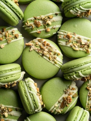 Pistachio Macarons are delicate, chewy, melt-in-your-mouth cookies filled with pistachio white chocolate ganache filling and chopped pistachios on top. | aheadofthyme.com