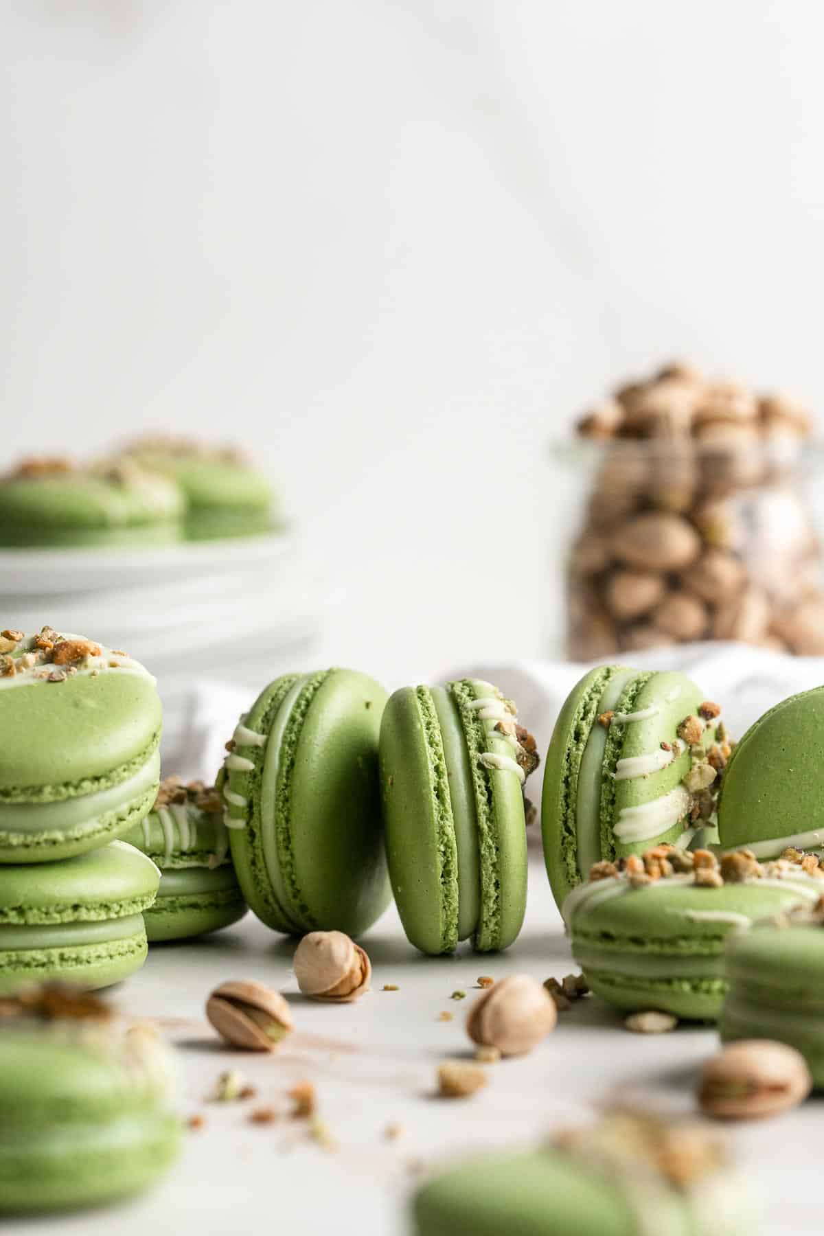 Pistachio Macarons are delicate, chewy, melt-in-your-mouth cookies filled with pistachio white chocolate ganache filling and chopped pistachios on top. | aheadofthyme.com