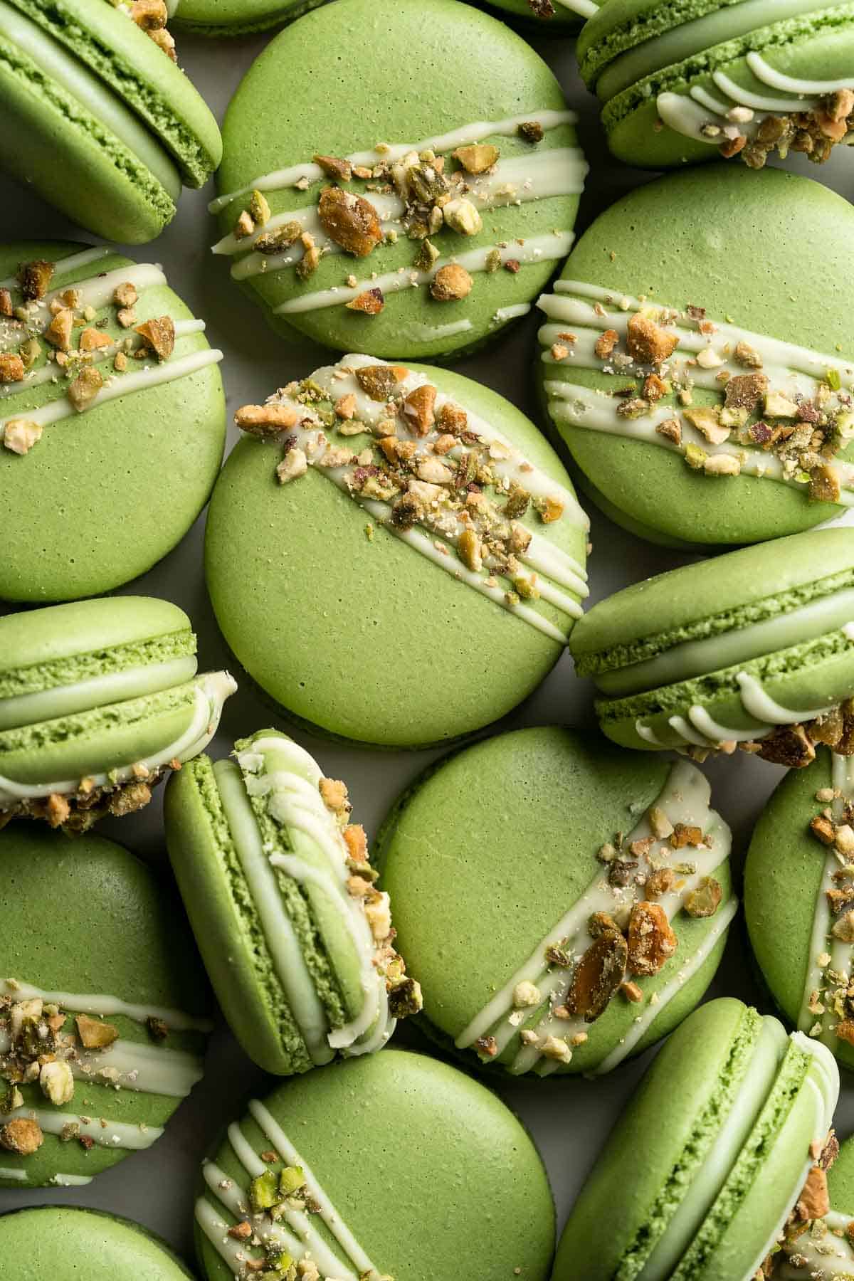 Pistachio Macarons are delicate, chewy, melt-in-your-mouth cookies filled with pistachio white chocolate ganache filling and chopped pistachios on top. | aheadofthyme.com