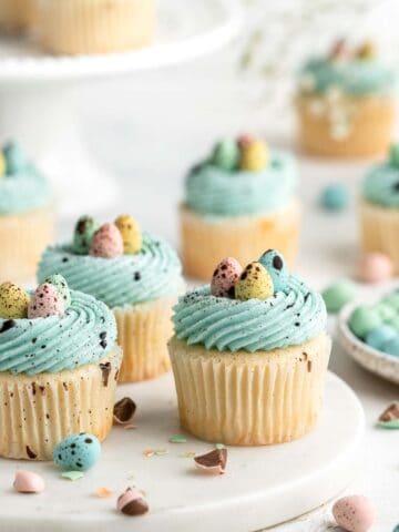 Robin’s Egg Cupcakes are an Easter treat you need to try! Fluffy vanilla cupcakes are topped with blue buttercream, mini eggs, and speckled with chocolate. | aheadofthyme.com