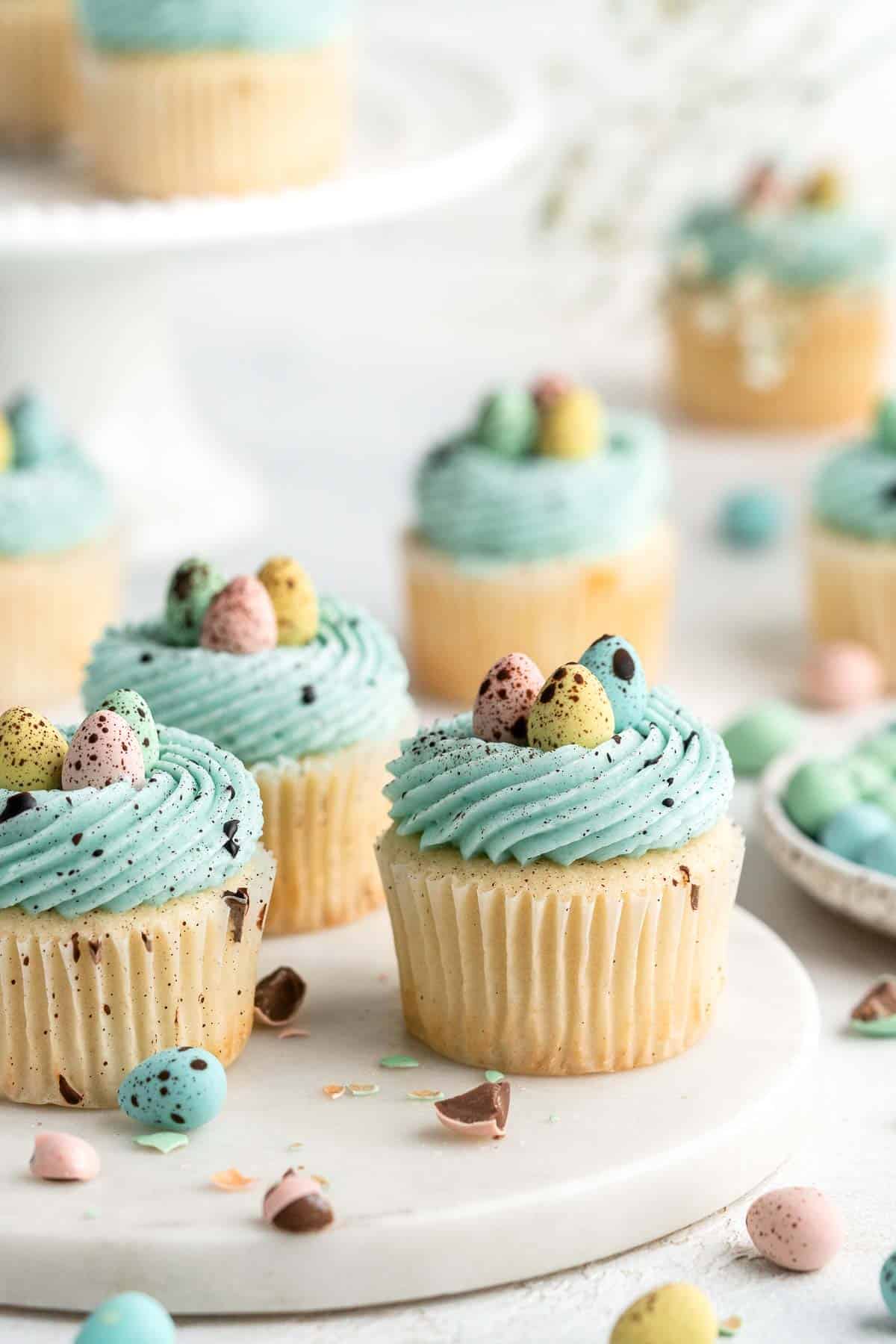 Robin’s Egg Cupcakes are an Easter treat you need to try! Fluffy vanilla cupcakes are topped with blue buttercream, mini eggs, and speckled with chocolate. | aheadofthyme.com
