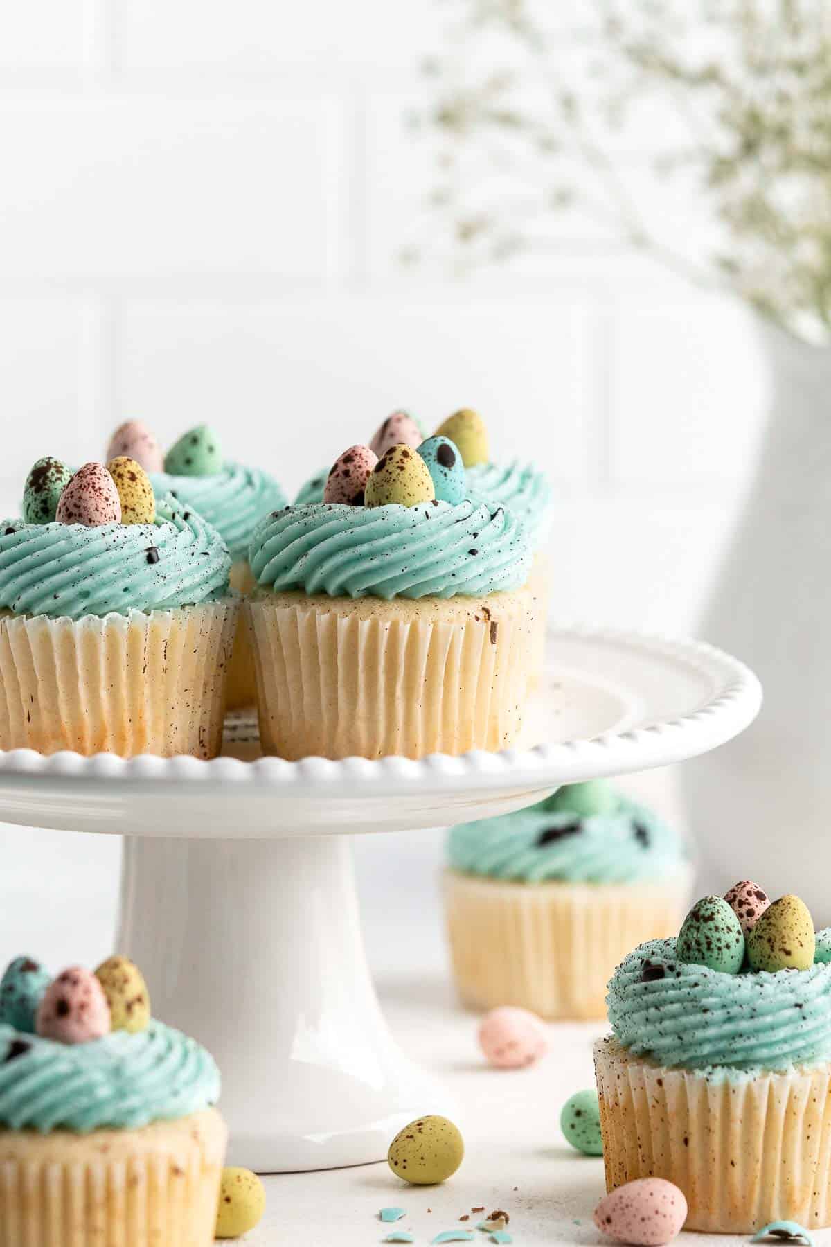 Robin’s Egg Cupcakes are an Easter treat you need to try! Fluffy vanilla cupcakes are topped with blue buttercream, mini eggs, and speckled with chocolate. | aheadofthyme.com