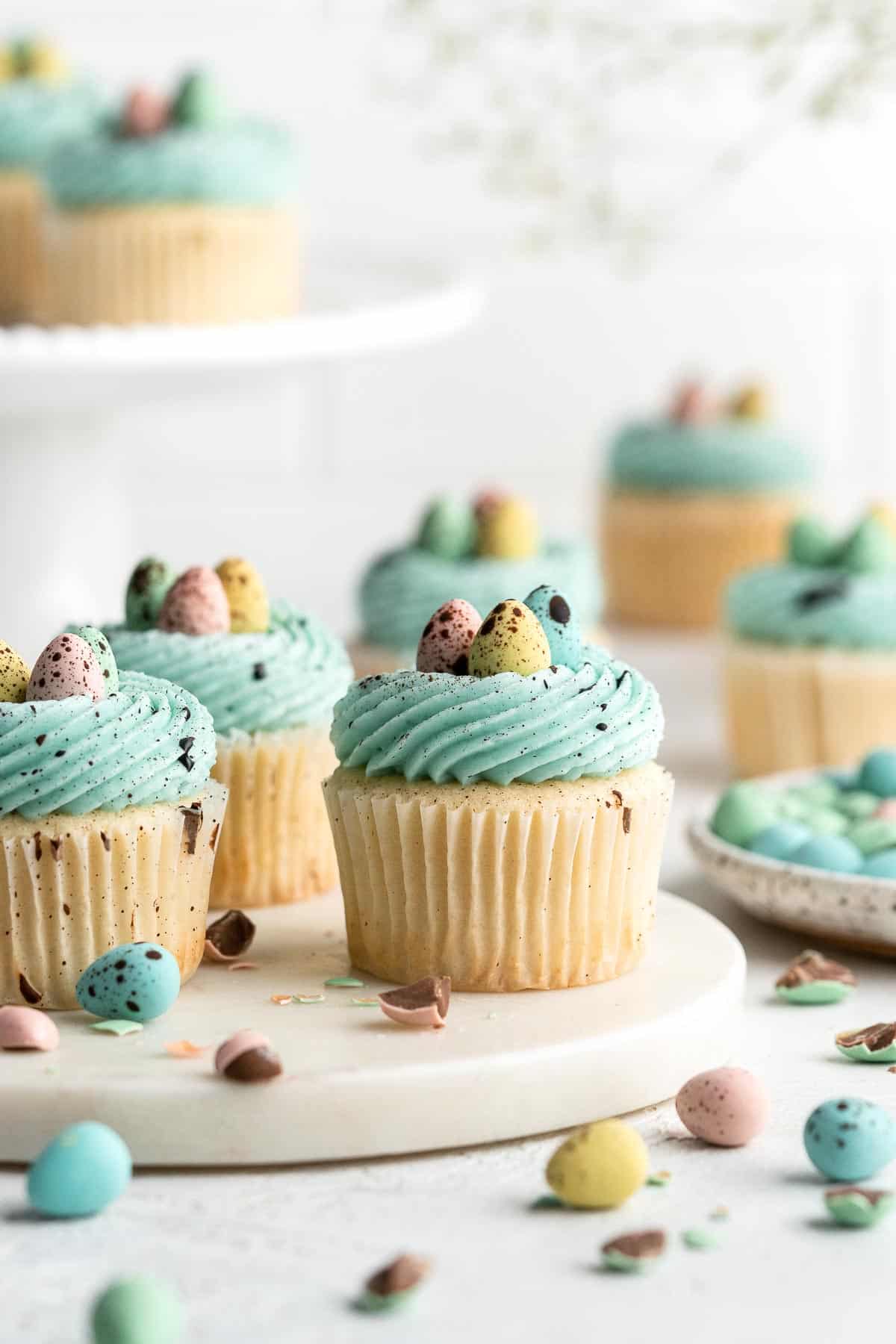 Robin’s Egg Cupcakes are an Easter treat you need to try! Fluffy vanilla cupcakes are topped with blue buttercream, mini eggs, and speckled with chocolate. | aheadofthyme.com