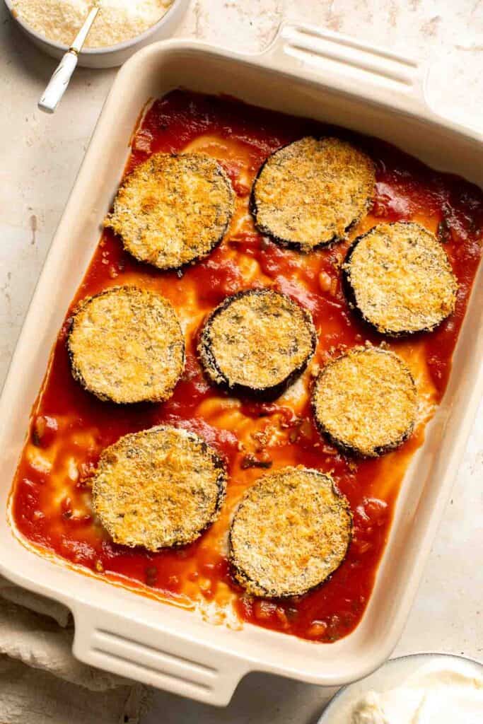 Eggplant Parmesan is a vegetarian Italian dish made featuring tender eggplant slices coated in crispy breadcrumbs, melty cheese, and baked in tomato sauce. | aheadofthyme.com