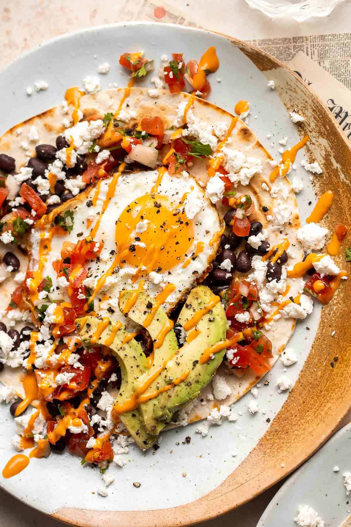 Huevos Rancheros is a classic Mexican breakfast dish that features fried eggs perched atop a bed of warm tortillas and beans and topped with salsa. | aheadofthyme.com