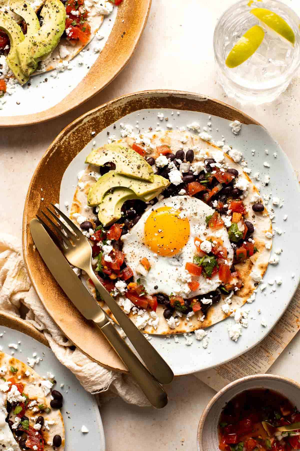 Huevos Rancheros is a classic Mexican breakfast dish that features fried eggs perched atop a bed of warm tortillas and beans and topped with salsa. | aheadofthyme.com