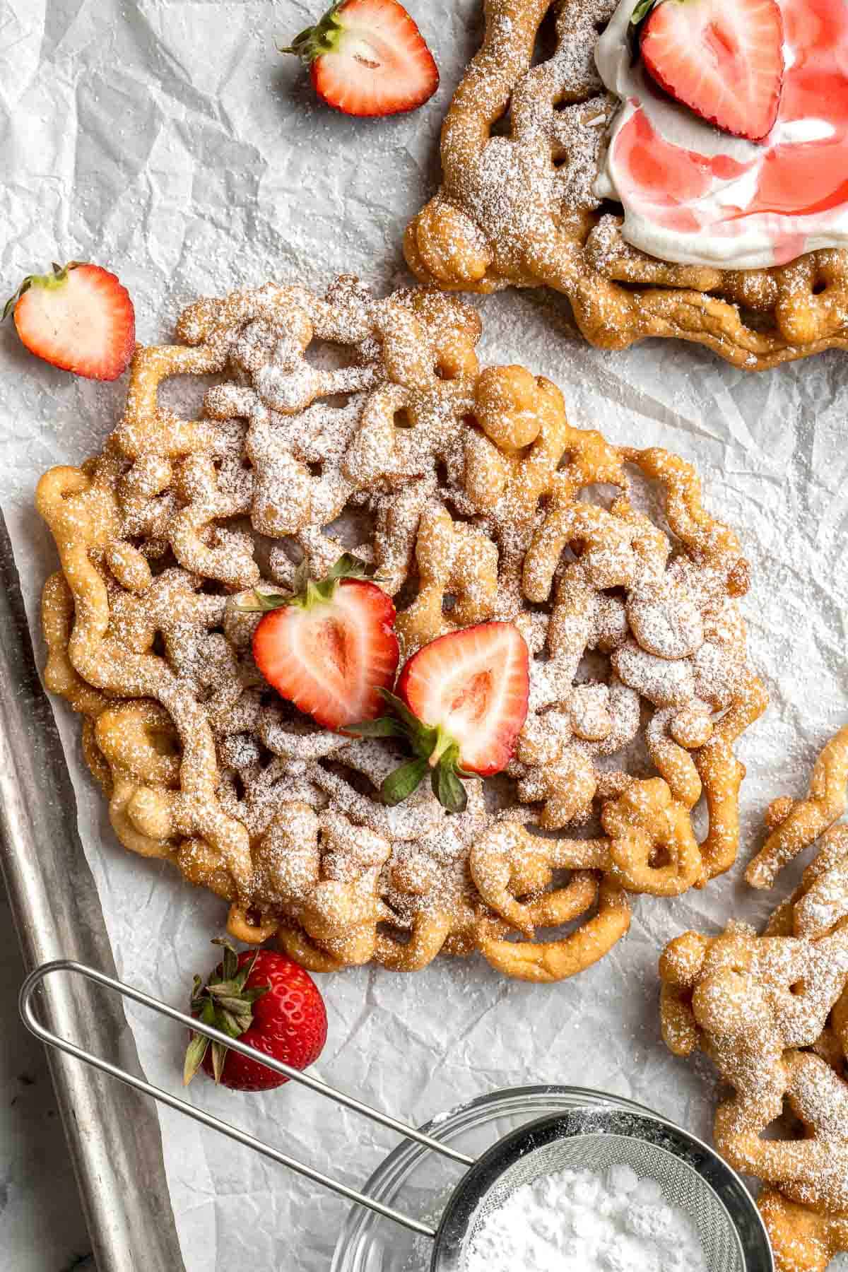 There’s truly nothing like a homemade Funnel Cake: a crispy jumble of crispy vanilla-tinged batter fried and topped with a powdered sugar, and served warm. | aheadofthyme.com