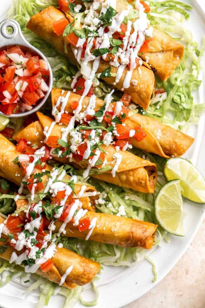 Homemade Taquitos are crispy, delicious and flavorful. These rolled tacos are filled with seasoned ground beef and melty cheese — and can be fried or baked! | aheadofthyme.com