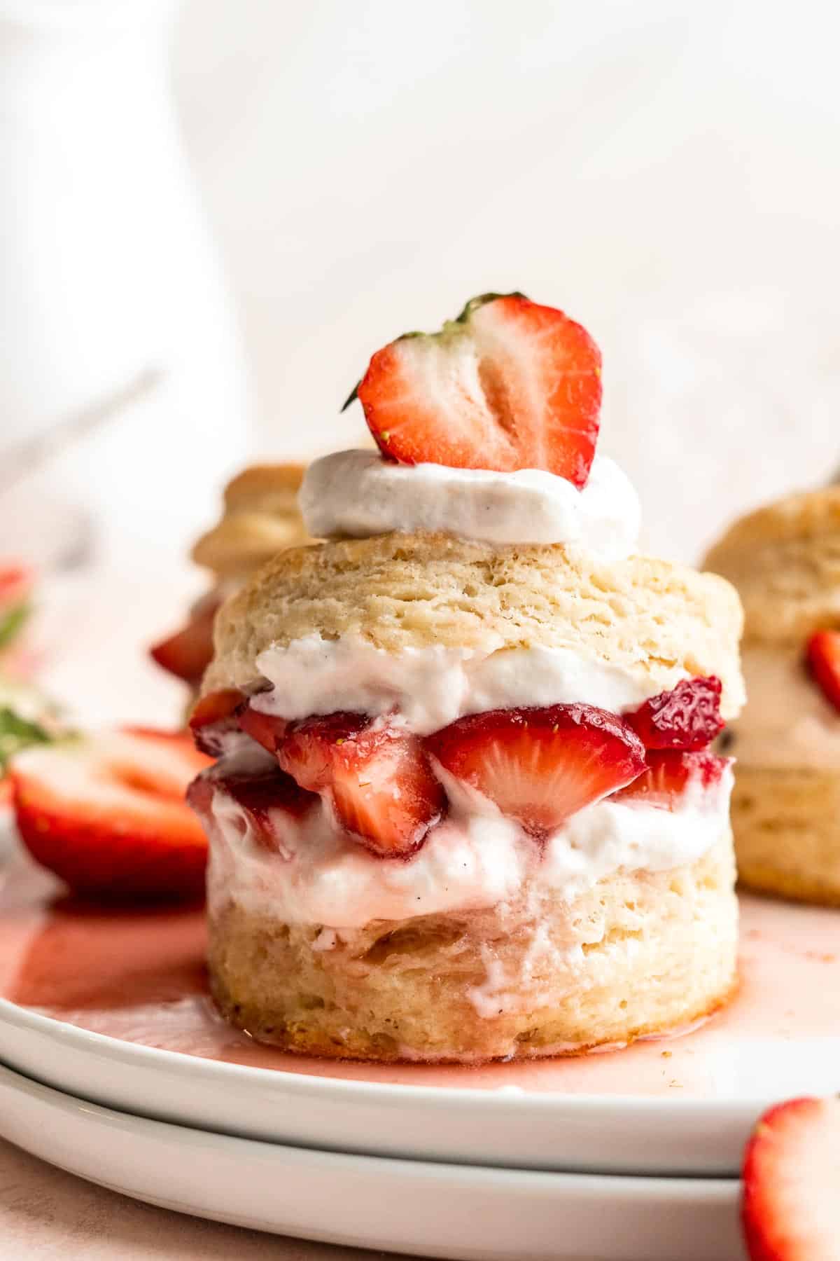 Classic Strawberry Shortcake is a small, layered cake featuring fluffy crumbly biscuits, a fresh strawberry filling, and homemade whipped cream. | aheadofthyme.com