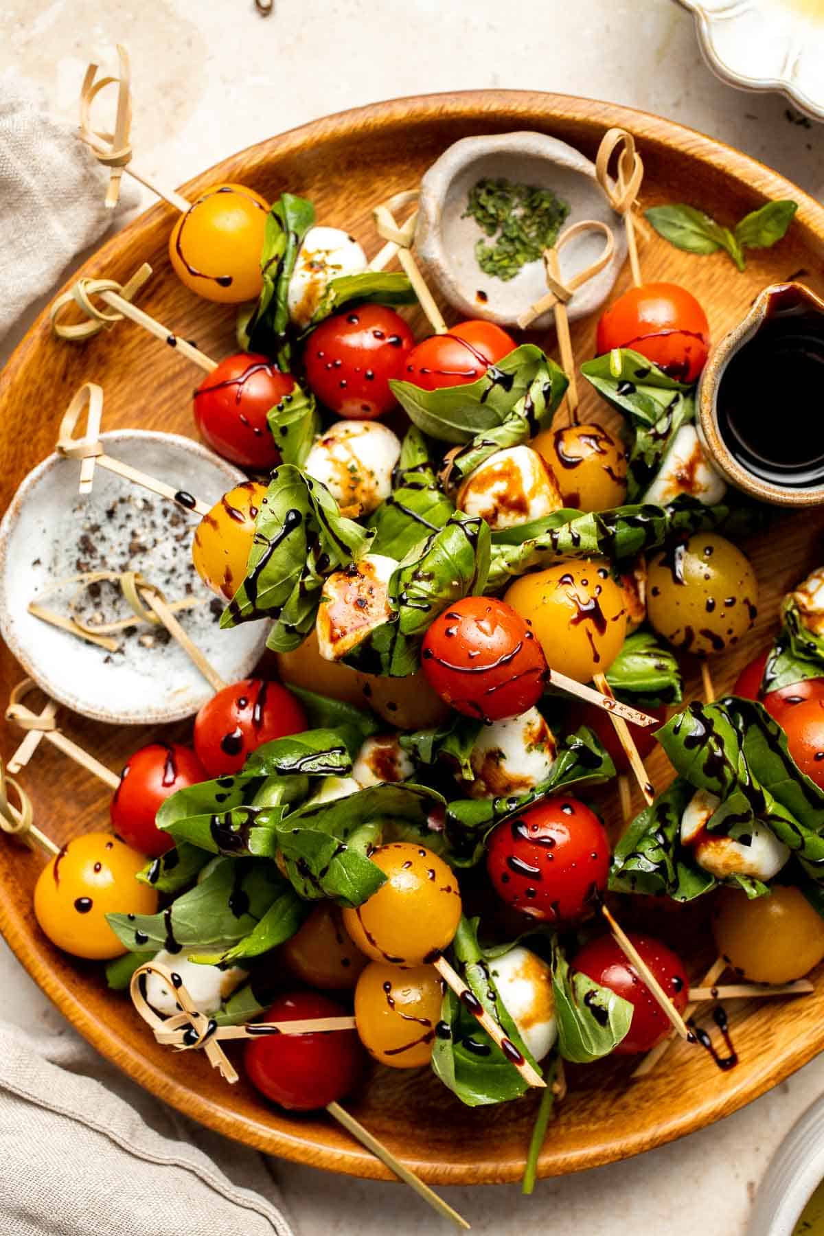 Caprese Skewers are a quick and fresh appetizer made with bite-sized mozzarella, juicy tomatoes, and basil leaves with a drizzle of balsamic glaze. | aheadofthyme.com