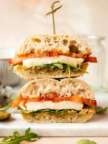 This vegetarian Caprese Sandwich is packed with layers of fresh tomatoes, mozzarella, greens, and a balsamic basil pesto sauce in between ciabatta buns. | aheadofthyme.com