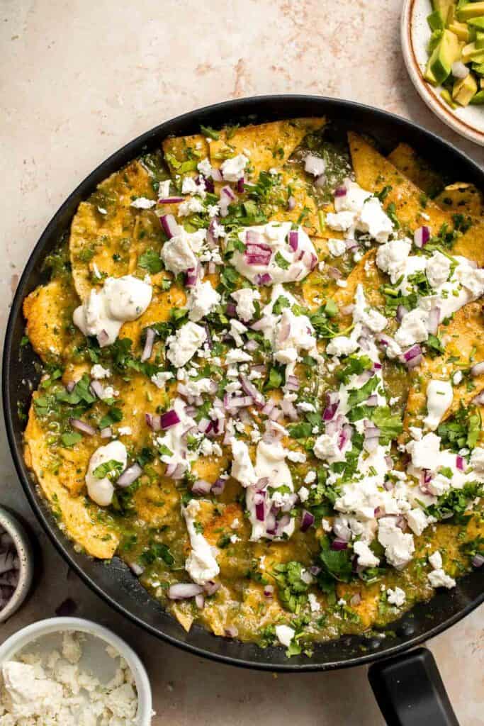 Chilaquiles Verdes feature crispy baked tortilla chips smothered in a homemade sauce loaded with salsa verde and features classic Mexican toppings. | aheadofthyme.com