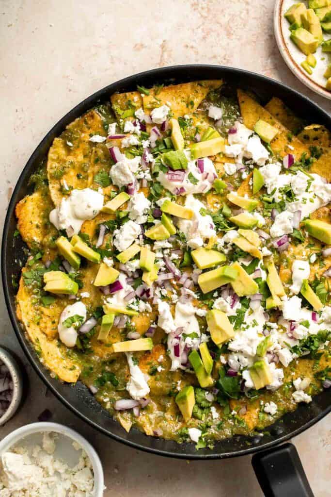 Chilaquiles Verdes feature crispy baked tortilla chips smothered in a homemade sauce loaded with salsa verde and features classic Mexican toppings. | aheadofthyme.com