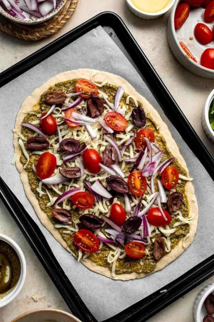 Mediterranean Flatbread is a zesty and cheesy vegetarian pizza, loaded with classic Mediterranean ingredients. It is quick and easy to make in 20 minutes. | aheadofthyme.com