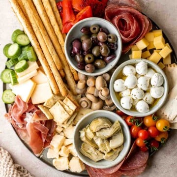 This Antipasto Platter is a show-stopping appetizer made with a variety of marinated veggies, olives, cheeses, breads, cured meats, and fresh vegetables. | aheadofthyme.com