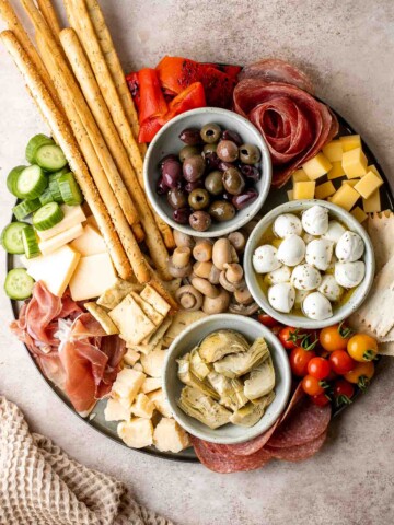 This Antipasto Platter is a show-stopping appetizer made with a variety of marinated veggies, olives, cheeses, breads, cured meats, and fresh vegetables. | aheadofthyme.com