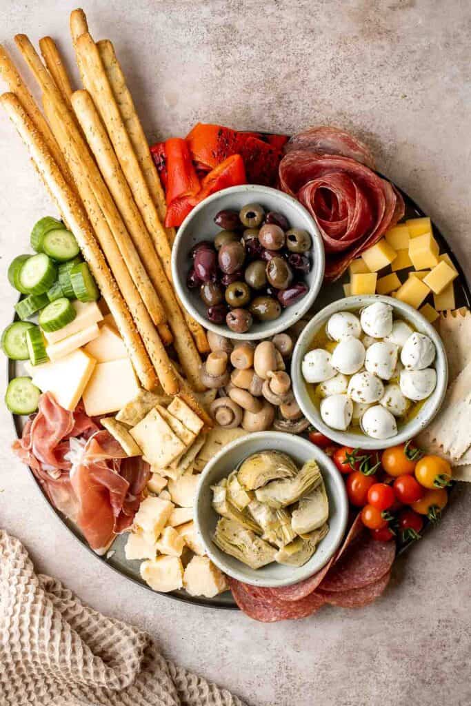 This Antipasto Platter is a show-stopping appetizer made with a variety of marinated veggies, olives, cheeses, breads, cured meats, and fresh vegetables. | aheadofthyme.com