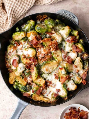 Cheesy Brussels Sprouts Bake is a comforting side dish made with sautéed garlic brussels sprouts, topped with bacon and cheese, and baked until bubbly. | aheadofthyme.com
